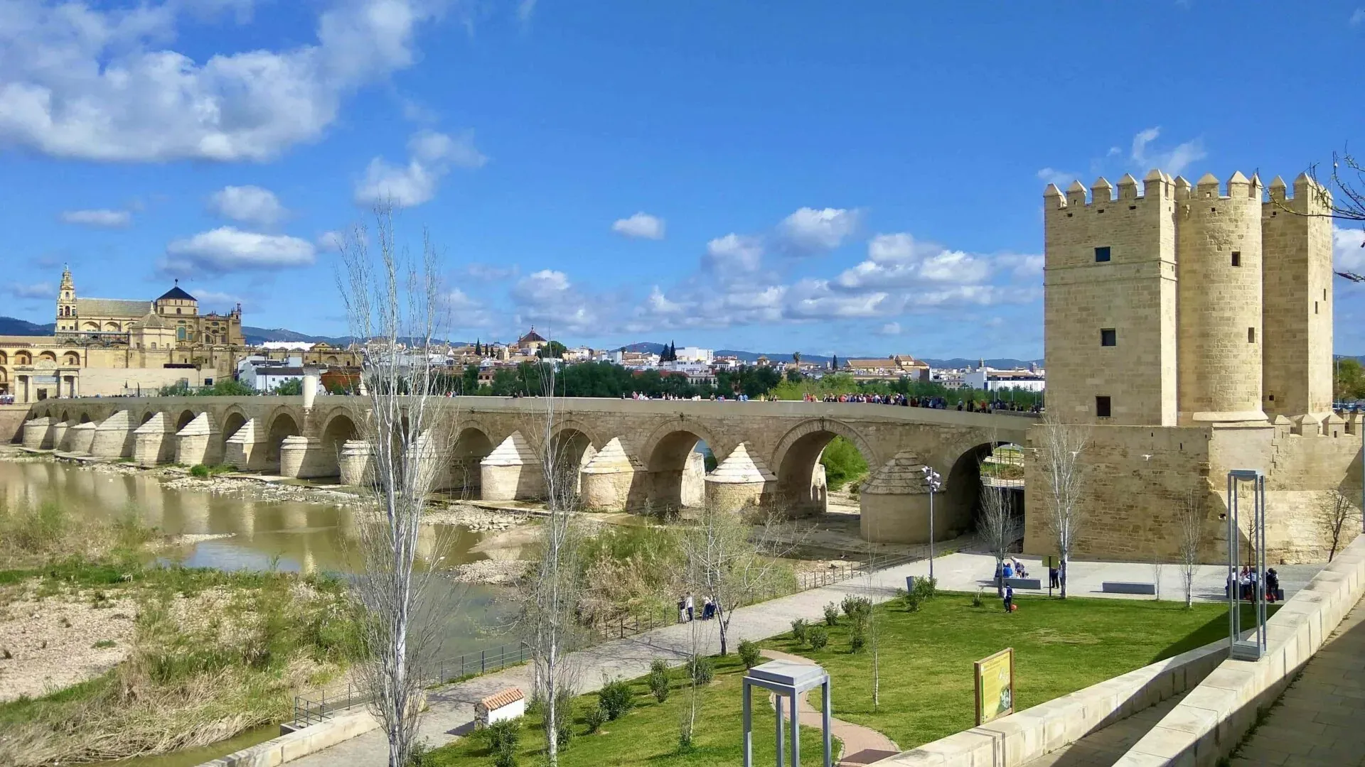 Tourists on the Roman Bridge in Cordoba, Spain, with the Mezquita-Cathedral in the background.