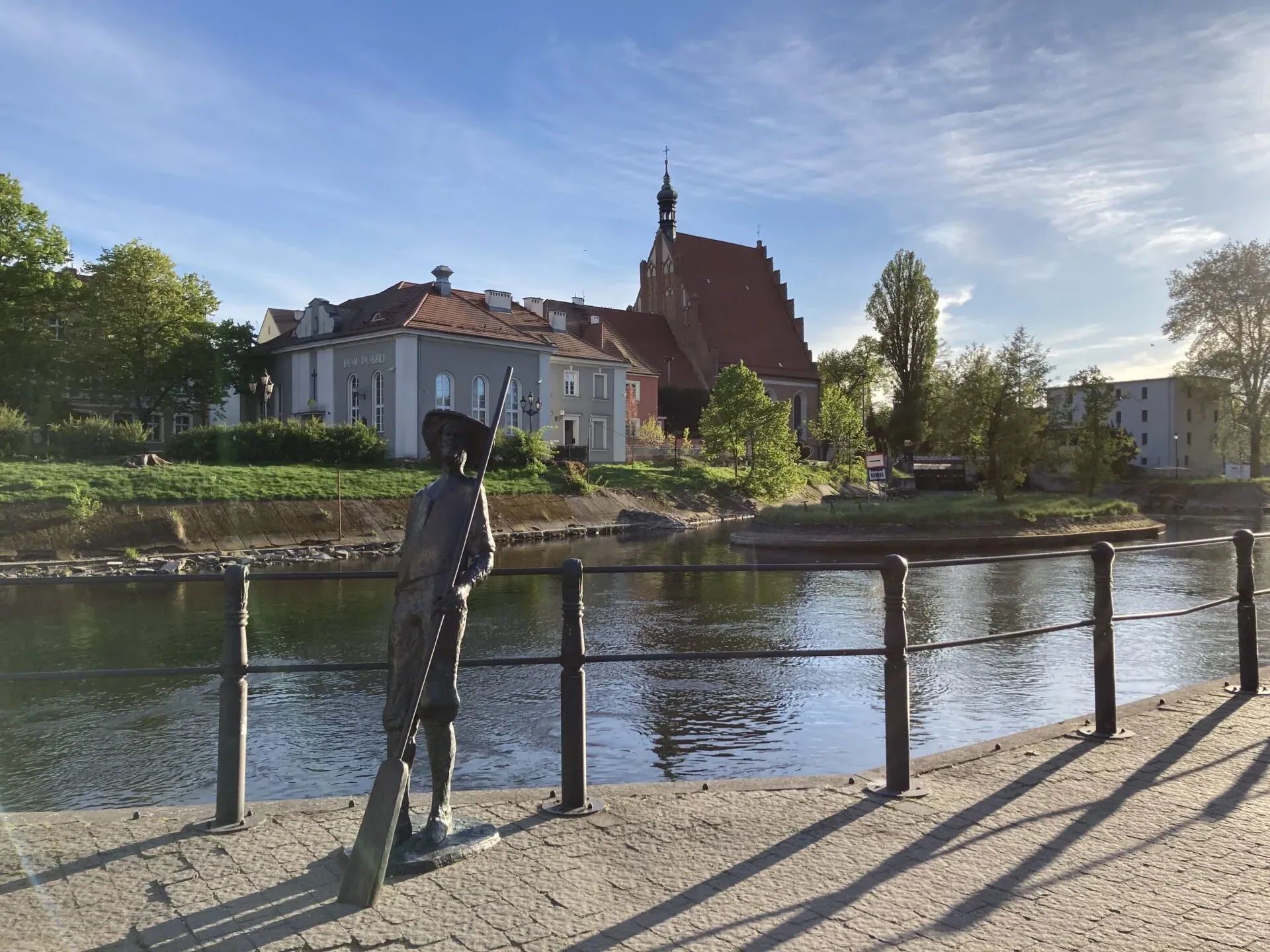 A bronze statue by a canal in Bydgoszcz's Old Town, Poland.