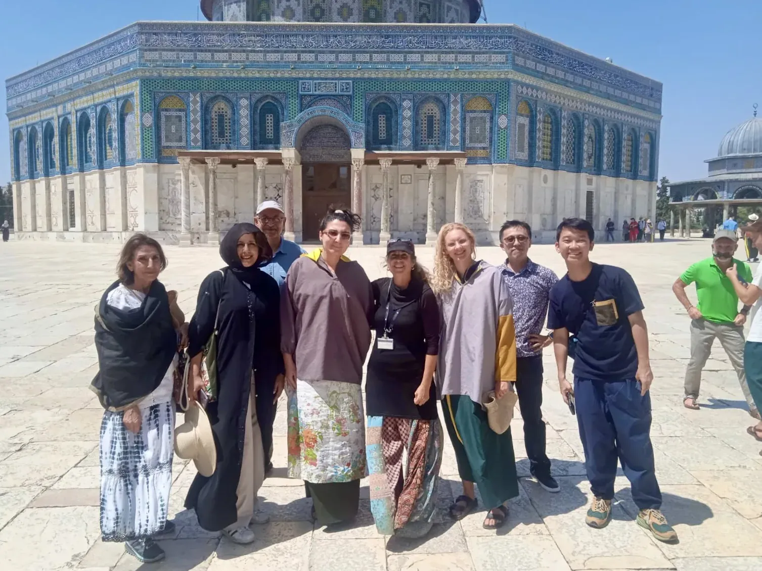 Happy tourists on a guided tour in front of the Dome of the Rock in Jerusalem.