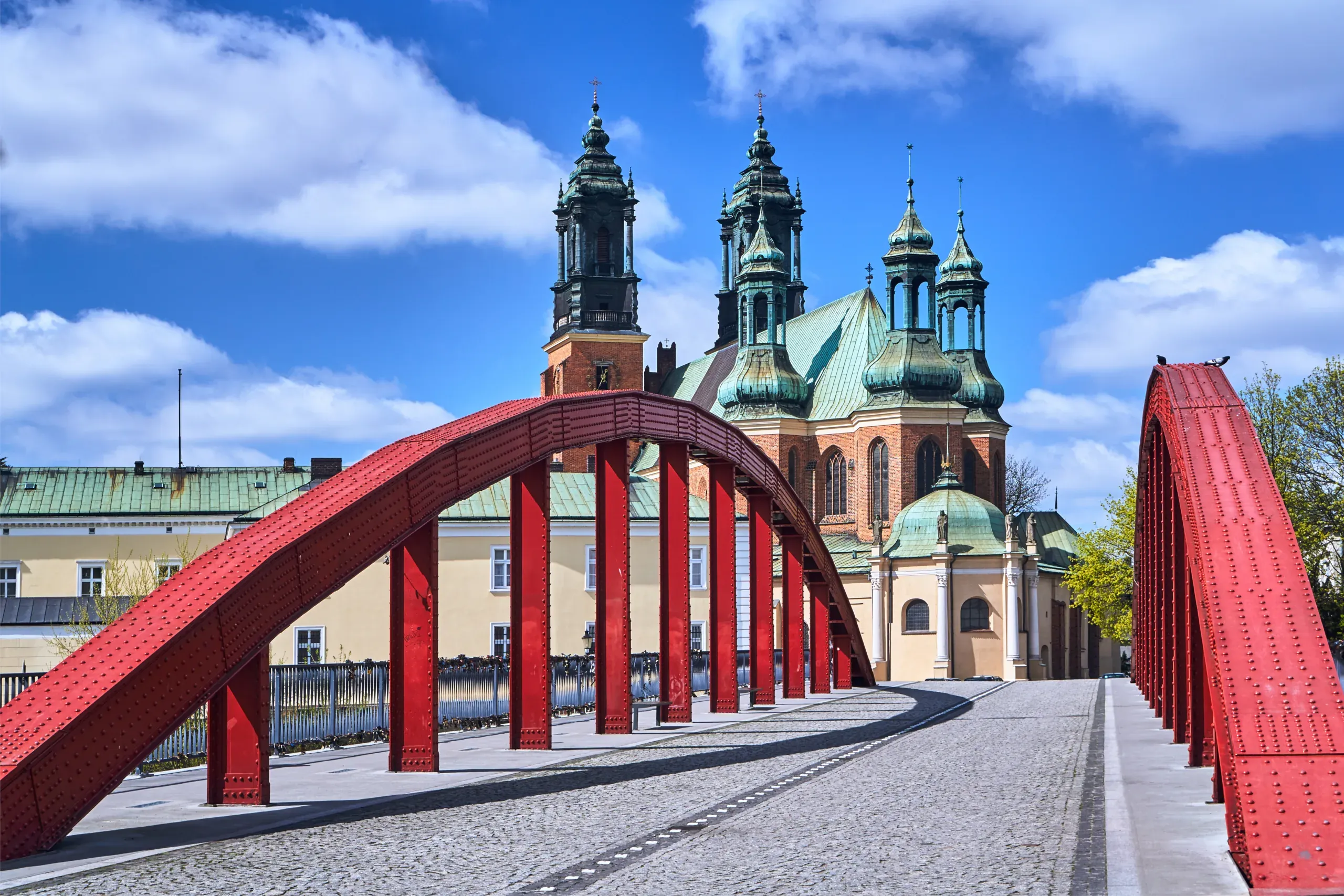 Red bridge in Poznan, Poland, with the Poznan Cathedral in the background.